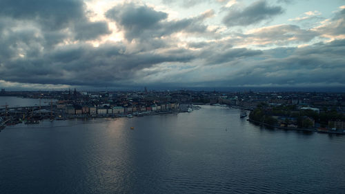 River amidst buildings in city against sky at dusk