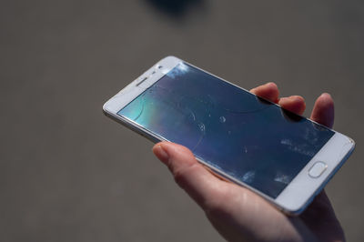 Cropped hand of woman using mobile phone