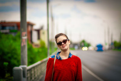 Portrait of smiling young man wearing sunglasses standing outdoors