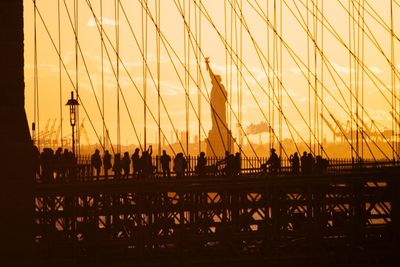 Silhouette people visiting statue of liberty during sunset