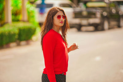 Portrait of young woman wearing sunglasses standing outdoors