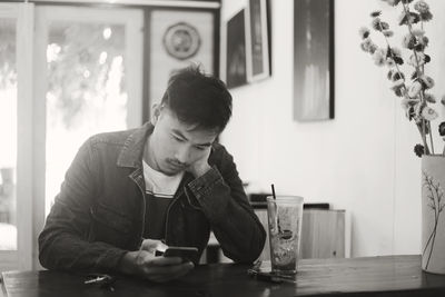 Man using mobile phone while sitting at home