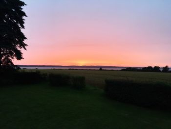 Scenic view of field against clear sky during sunset
