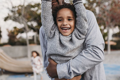 Close up of happy son and father playing on playground at dusk