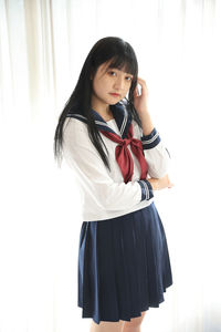 Side view of young woman drinking wine while standing against white background