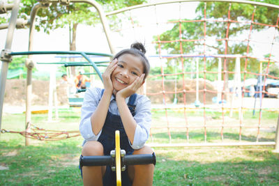 Portrait of girl sitting on spring ride at park