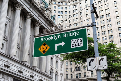 Road sign by building in city