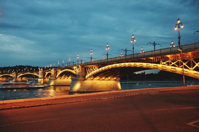 Bridge over river against sky in city
