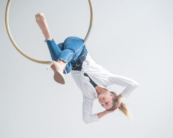 Low angle view of boy jumping against clear sky