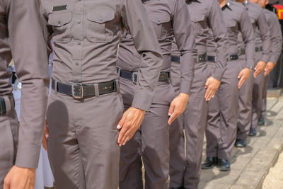 People in uniforms standing on footpath