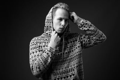 Young man looking away against black background