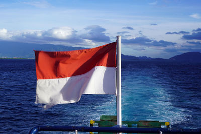 Flag on sea against sky