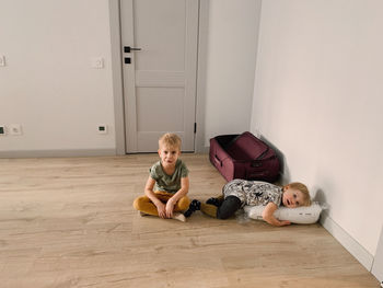 Portrait of children sitting on the floor of the house