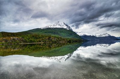 Scenic view of lake by snowcapped mountain against sky