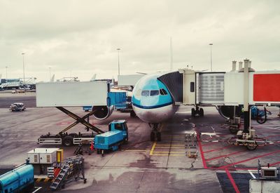 Airplane on airport runway against sky