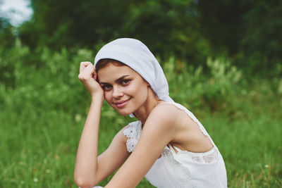 Portrait of young woman standing against plants