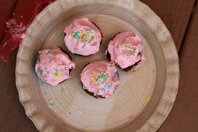 This is a frosted cupcake with sprinkleson a ceramic platter