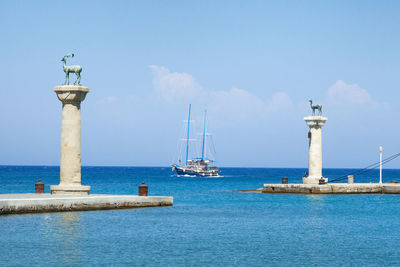 Lighthouse by sea against sky