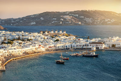 High angle view of townscape by sea against clear sky during sunset