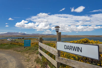 Information sign on road against sky