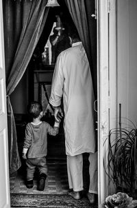 Rear view of grandfather and grandson at home