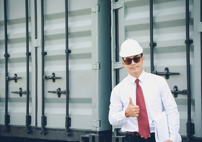 Portrait of architect standing against metal structure