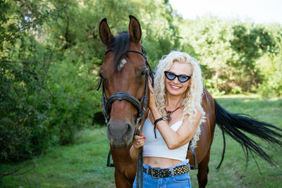 Beautiful woman with horse in summer park