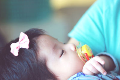 Close-up portrait of girl holding leaf