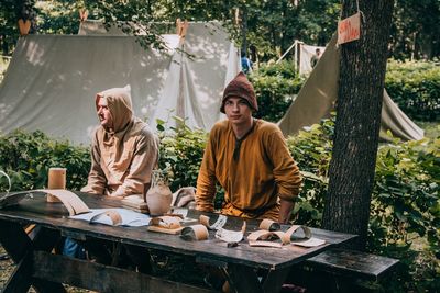 People sitting on table against trees