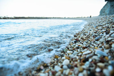 Close-up of pebbles on beach against sky