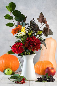 Elegant autumn bouquet with ripe apples and pumpkin on table. thanksgiving day