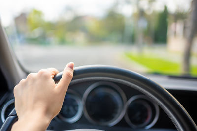 Cropped hand of man driving car