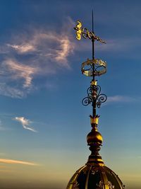 Low angle view of weather vane against sky