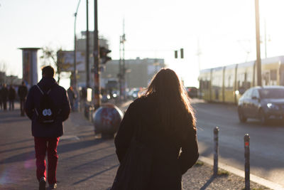 Rear view of women walking on street in city