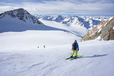 Rear view of people skiing on snowcapped mountain