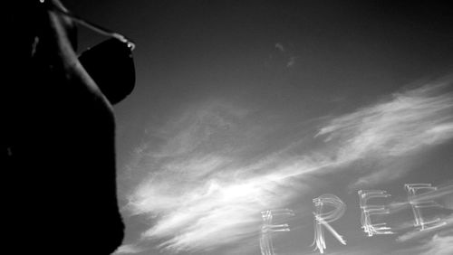 Low angle view of silhouette text against sky