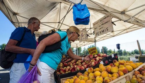 Man standing by fruits in market stall