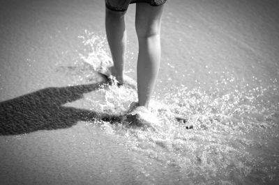 Low section of woman standing in water