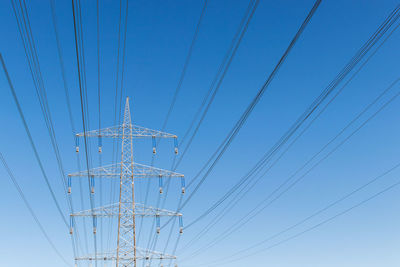 High voltage power pylon and cables - low angle view of cables against sky