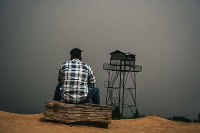 Rear view of man standing against clear sky