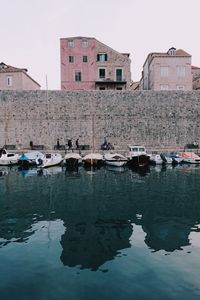 Boats moored by houses against clear sky