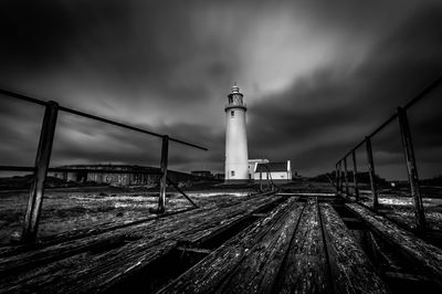 Low angle view of lighthouse against cloudy sky