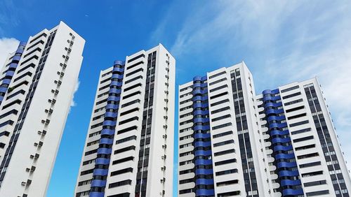 Low angle view of modern buildings against blue sky
