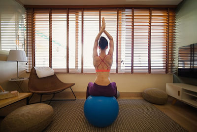 Rear view of woman exercising at home