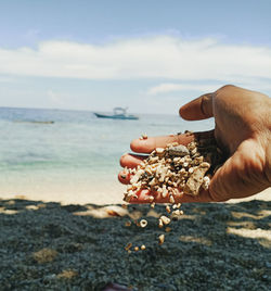 Midsection of person holding umbrella on beach