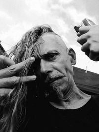 Low angle view of man holding woman against sky