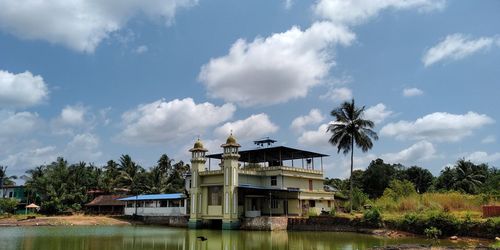 Building by lake against sky