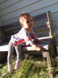 Cute boy sitting on wood