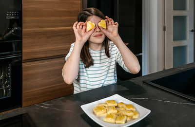 Young woman having food at home