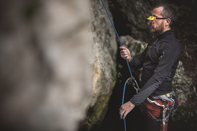 Side view of man rock climbing